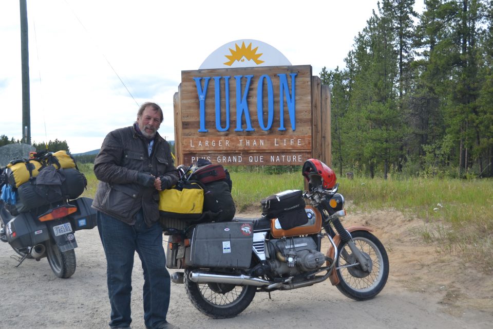 Bob Congdon with his motorcycle at the Yukon sign during his Alaska Journey.